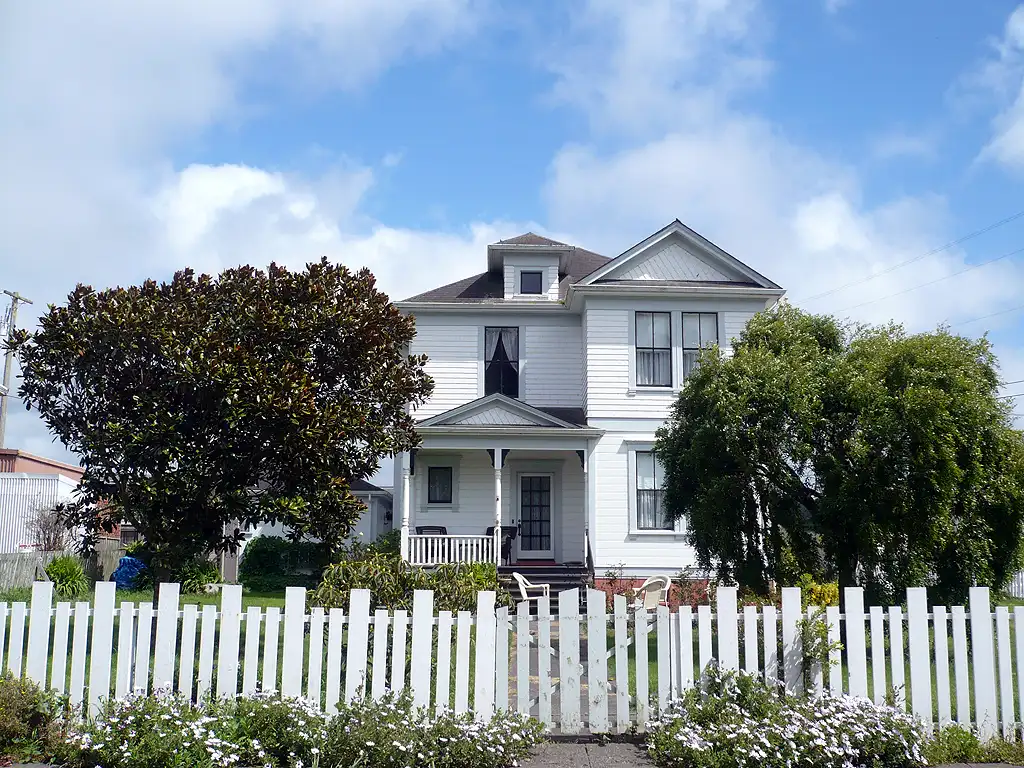 White picket fence in front of a classic two-story home